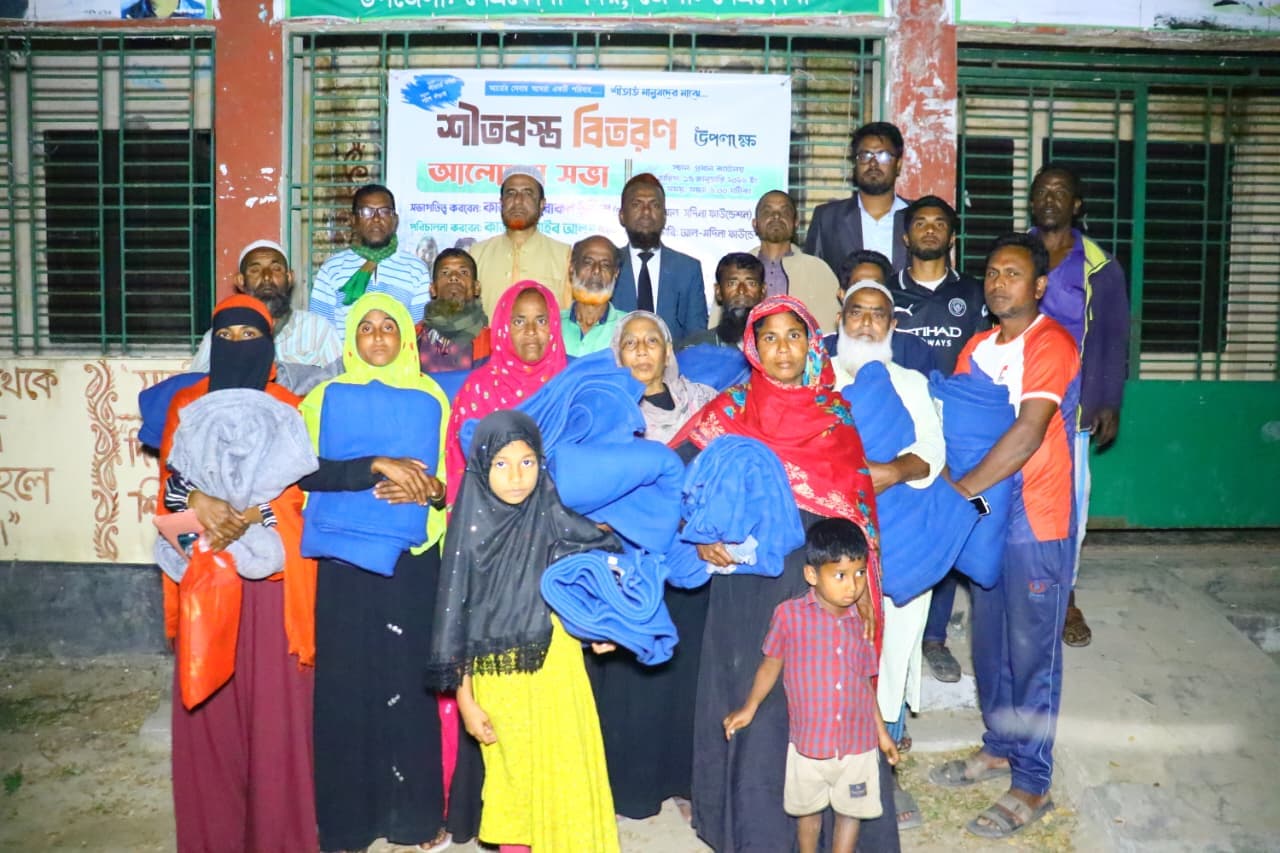 ভবনের সামনে শিশু ও বড়রা নীল কম্বল নিয়ে দলীয় ছবিতে দাঁড়িয়ে আছেন।
